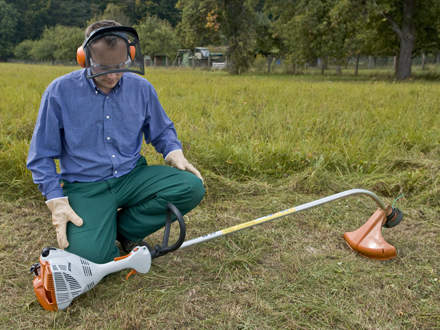 : Step 1 of 10: Laying the brushcutter on the groundLay the brushcutter down in a safe position on the ground. It should rest on the support on the engine and the cutting attachment guard. Make sure that the cutting attachment is not touching the ground or any other object as it may start to rotate when you start the engine. Keep everyone else at least 15 m away from the machine. Make sure you have a steady footing.