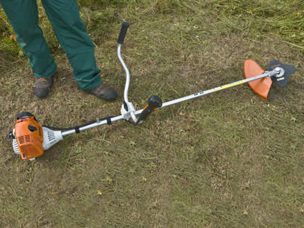 : Step 1 of 14: Laying the brushcutter on the groundLay the brushcutter down in a safe position on the ground. It should rest on the support on the engine and the cutting attachment guard. Make sure that the cutting attachment is not touching the ground or any other object as it may start to rotate when you start the engine. Keep everyone else at least 15 m away from the machine. Make sure you have a steady footing.