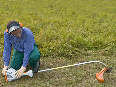 : Step 5 of 10: Secure footing / pushing the brushcutter onto the ground Make sure you have a secure footing and check once again that the brushcutter is lying in a secure position. Push the machine firmly down onto the ground so that it cannot tilt when starting. Check that the cutting attachment is not touching anything.